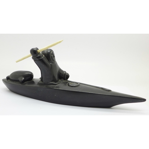 638 - A carved soapstone model of an Inuit in a canoe, 26.5cm