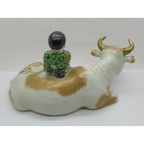 646 - A china figure of a boy sitting on a cow