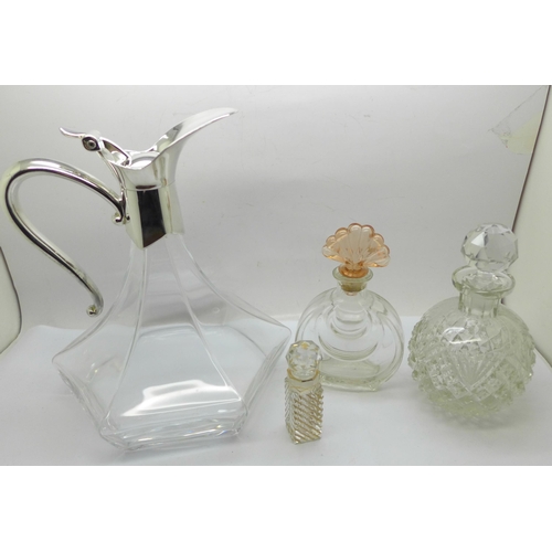 659 - A glass claret jug with plated top and three scent bottles