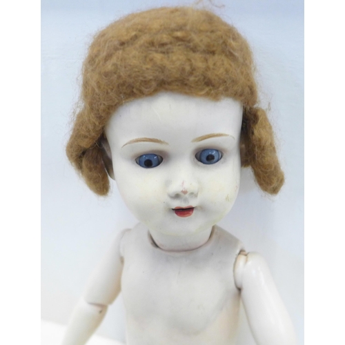 799 - A composite doll with porcelain head and two smaller dolls