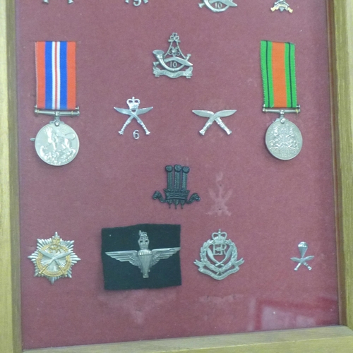 819 - A collection of Ghurka badges and two WWII medals in a display case