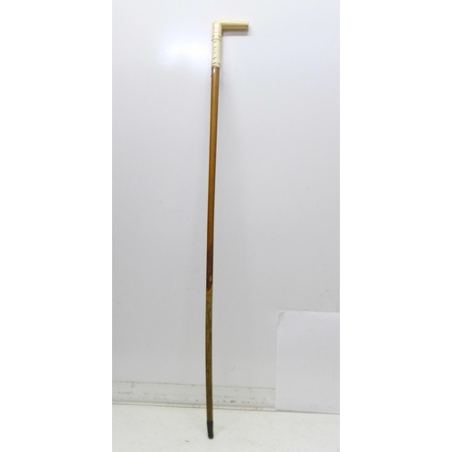 852 - A 19th Century gentleman's walking stick, the L-shaped ivory handle carved with faux buttoned straps... 