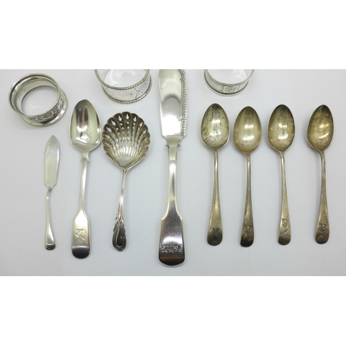 907 - A collection of silver including a George IV silver spreader and two napkin rings, etc., a plated na... 