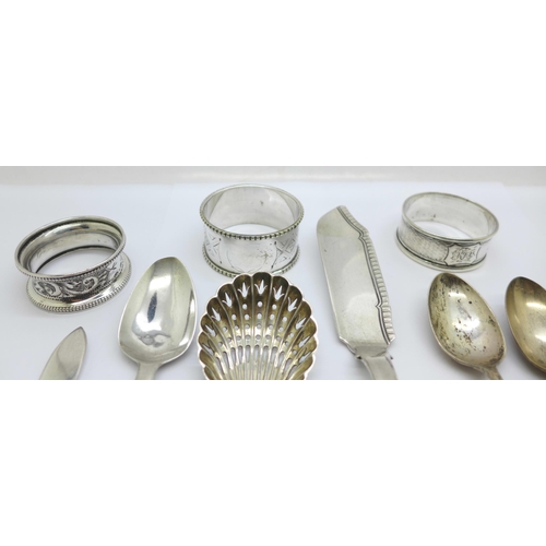 907 - A collection of silver including a George IV silver spreader and two napkin rings, etc., a plated na... 