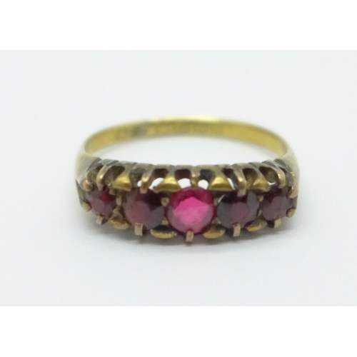 951 - An 18ct gold five stone ring, set with four garnets and replacement red centre stone, Birmingham 190... 