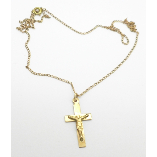 974 - A 9ct gold crucifix on a yellow metal chain, 2.2g, (tests as 9ct)