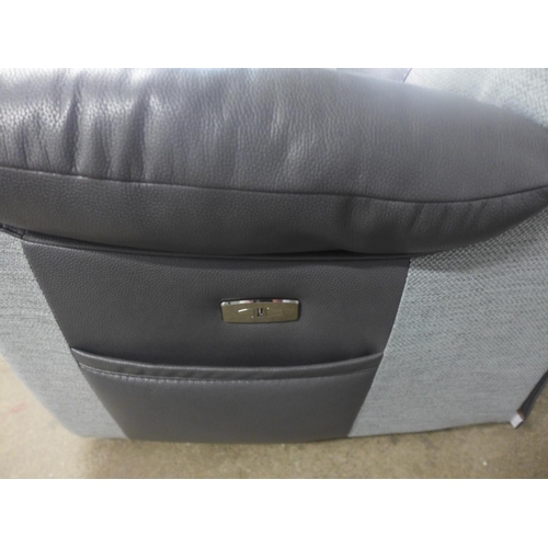 1510 - A black and grey upholstered electric reclining three seater sofa - damage, tear on the back of the ... 