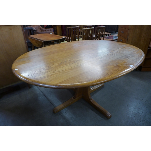 111 - An Ercol elm and beech pedestal dining table