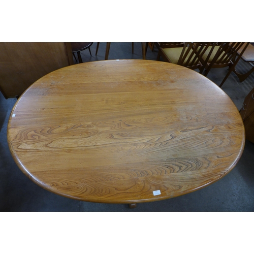 111 - An Ercol elm and beech pedestal dining table