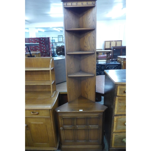 112 - An Ercol Golden Dawn elm and beech freestanding corner cabinet