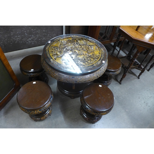 148 - An eastern carved hardwood circular table and four stools