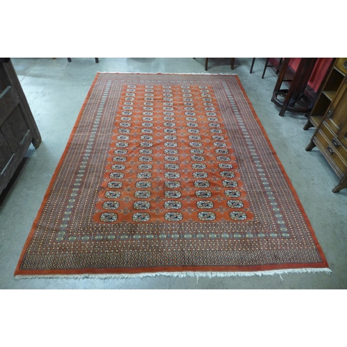 15 - A Pakistani hand knotted red ground Bokhara rug, 268 x 195cms