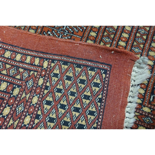 15 - A Pakistani hand knotted red ground Bokhara rug, 268 x 195cms