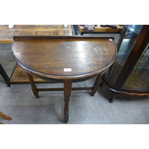 181 - An oak demi-lune hall table