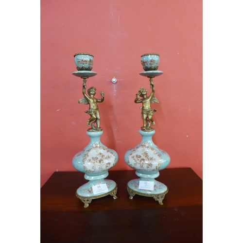 23 - A pair of French style porcelain and ormolu mounted figural cherub candlesticks