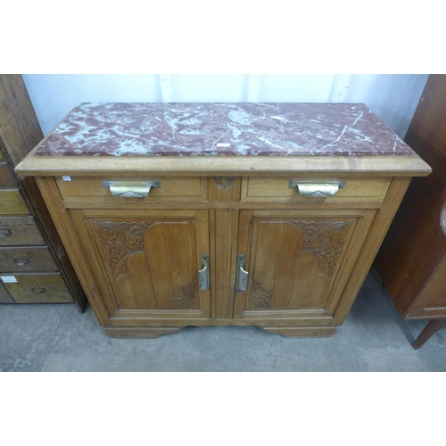 236 - A carved oak and marble topped sideboard