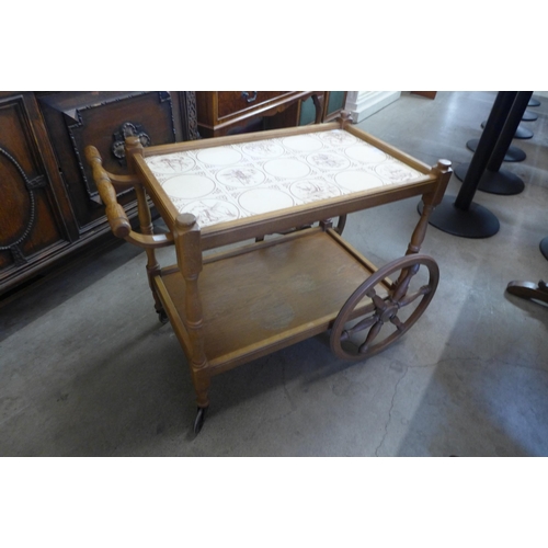 258 - An oak and tiled topped cartwheel trolley