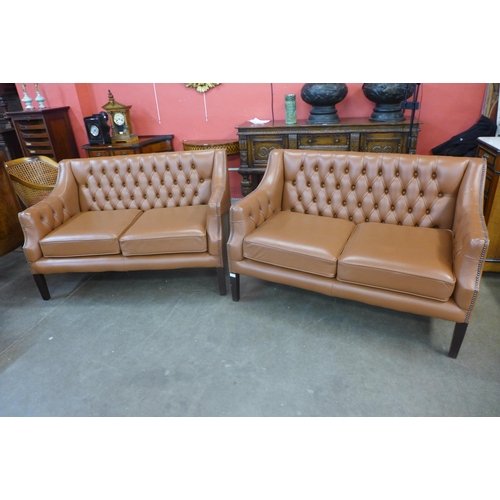 31 - A pair of mahogany and brown leather buttoned settees