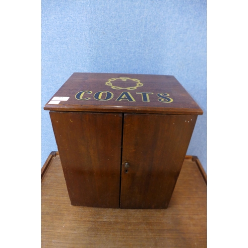 363 - A small mahogany two door counter top shop cabinet, bearing later Coats painted inscription