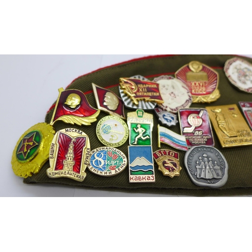 622 - A Soviet cap with a collection of badges