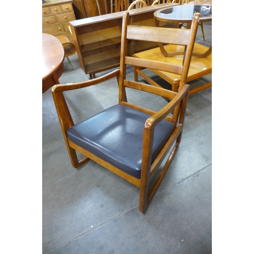 109 - A teak and faux leather rocking chair