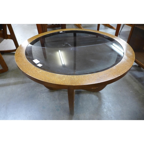 110 - A teak and glass topped circular coffee table