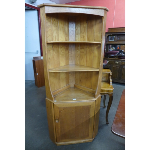 117 - An Ercol Blonde elm and beech freestanding corner cabinet