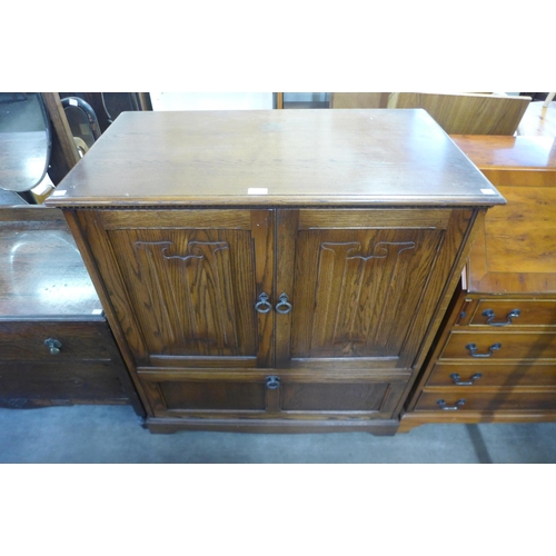 241 - An oak linenfold panel TV cabinet