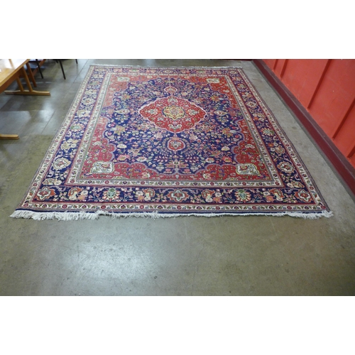 31 - A large Persian red ground geometric patterned Tabriz rug, 355 x 304cms