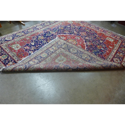 31 - A large Persian red ground geometric patterned Tabriz rug, 355 x 304cms