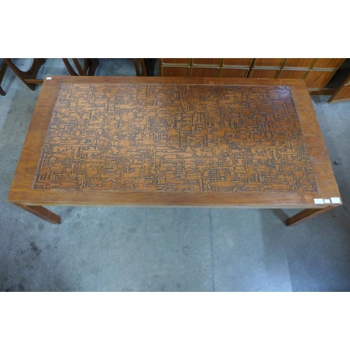 65 - A teak and embossed copper topped coffee table