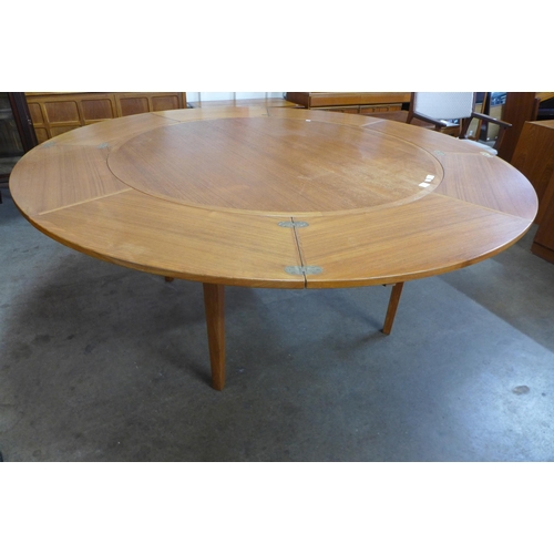 66 - A Danish Dyrlund teak circular flip flap dining table