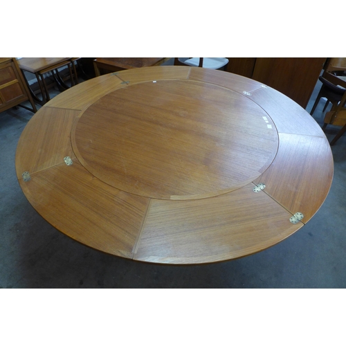 66 - A Danish Dyrlund teak circular flip flap dining table