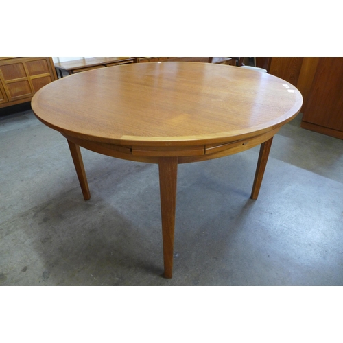 66 - A Danish Dyrlund teak circular flip flap dining table