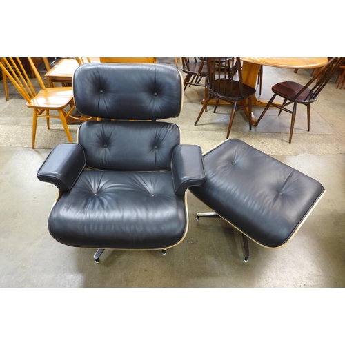 97 - A Charles & Ray Eames style black leather and simulated rosewood revolving lounge chair and stool