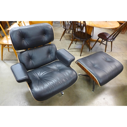 97 - A Charles & Ray Eames style black leather and simulated rosewood revolving lounge chair and stool