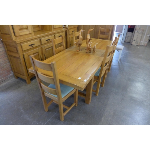 1557 - A French oak extending dining table and six ladderback chairs