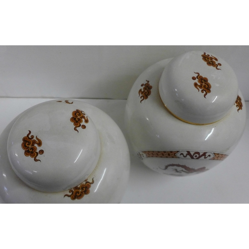 609 - A pair of Carlton Ware ginger jars decorated with oriental dragons, 22cm