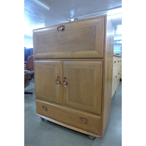 75 - An Ercol Blonde elm 469 model writing desk/cabinet