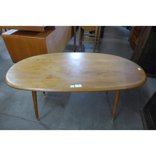 96 - An Ercol Blonde elm topped coffee table, on associated beech legs