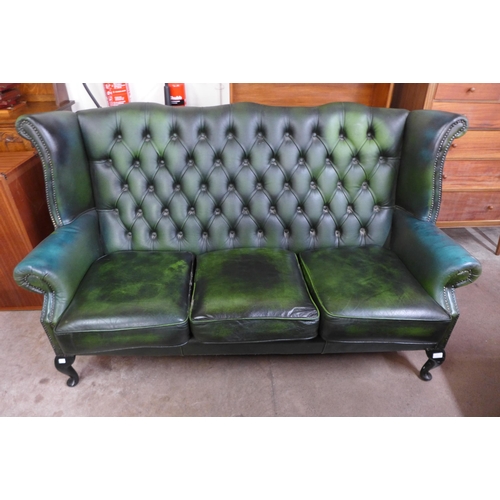 251 - A green leather Chesterfield wingback settee ( tear to seat cushion)