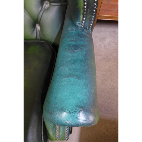 251 - A green leather Chesterfield wingback settee ( tear to seat cushion)