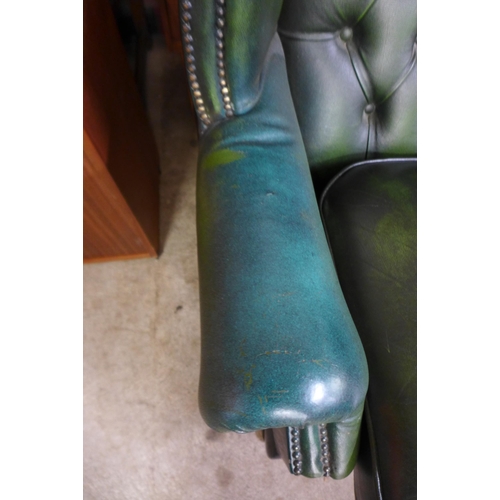 251 - A green leather Chesterfield wingback settee ( tear to seat cushion)