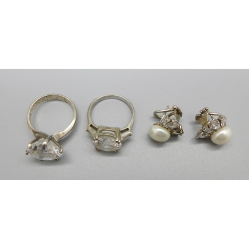 1030 - Two large silver and CZ rings and a pair of silver and faux pearl earrings