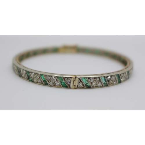 1056 - An Art Deco diamond and emerald set bangle with gold back and silver setting/front, the emeralds set... 