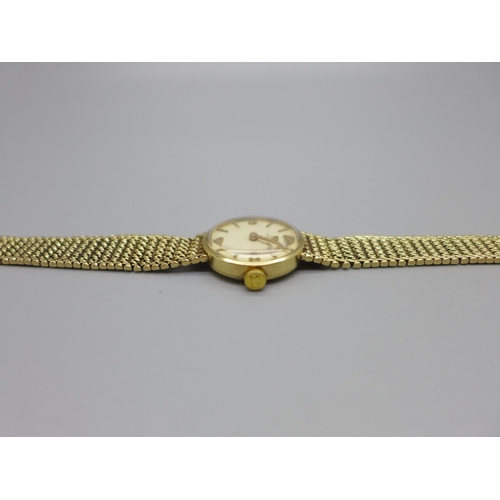 1129 - A lady's 9ct gold Omega wristwatch with integrated bracelet strap, total weight with movement 21.7g