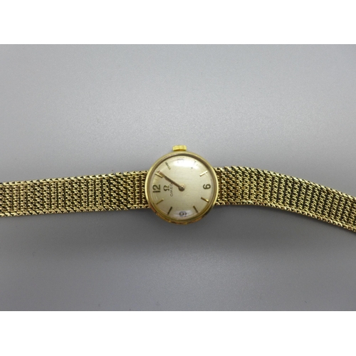 1129 - A lady's 9ct gold Omega wristwatch with integrated bracelet strap, total weight with movement 21.7g