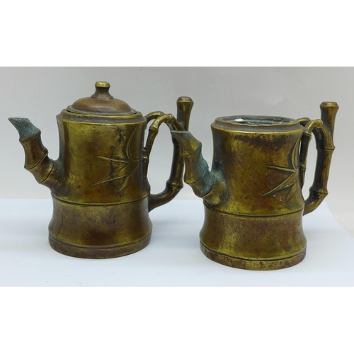 642 - Two small bronze pots with spouts and bamboo style handles, one lacking lid