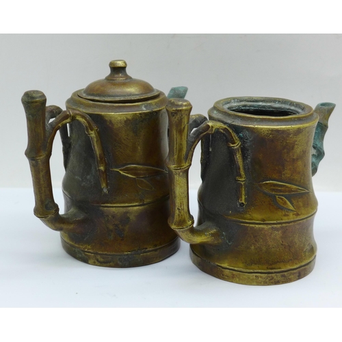 642 - Two small bronze pots with spouts and bamboo style handles, one lacking lid