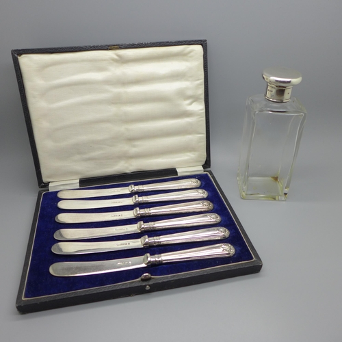 892 - A silver topped glass dressing table bottle and six butter knives